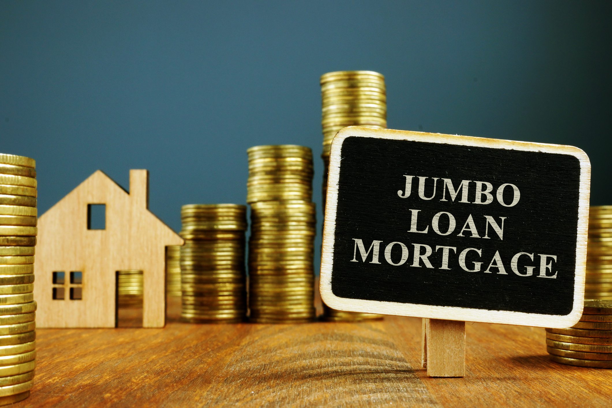 Jumbo loan mortgage sign with coins, house.