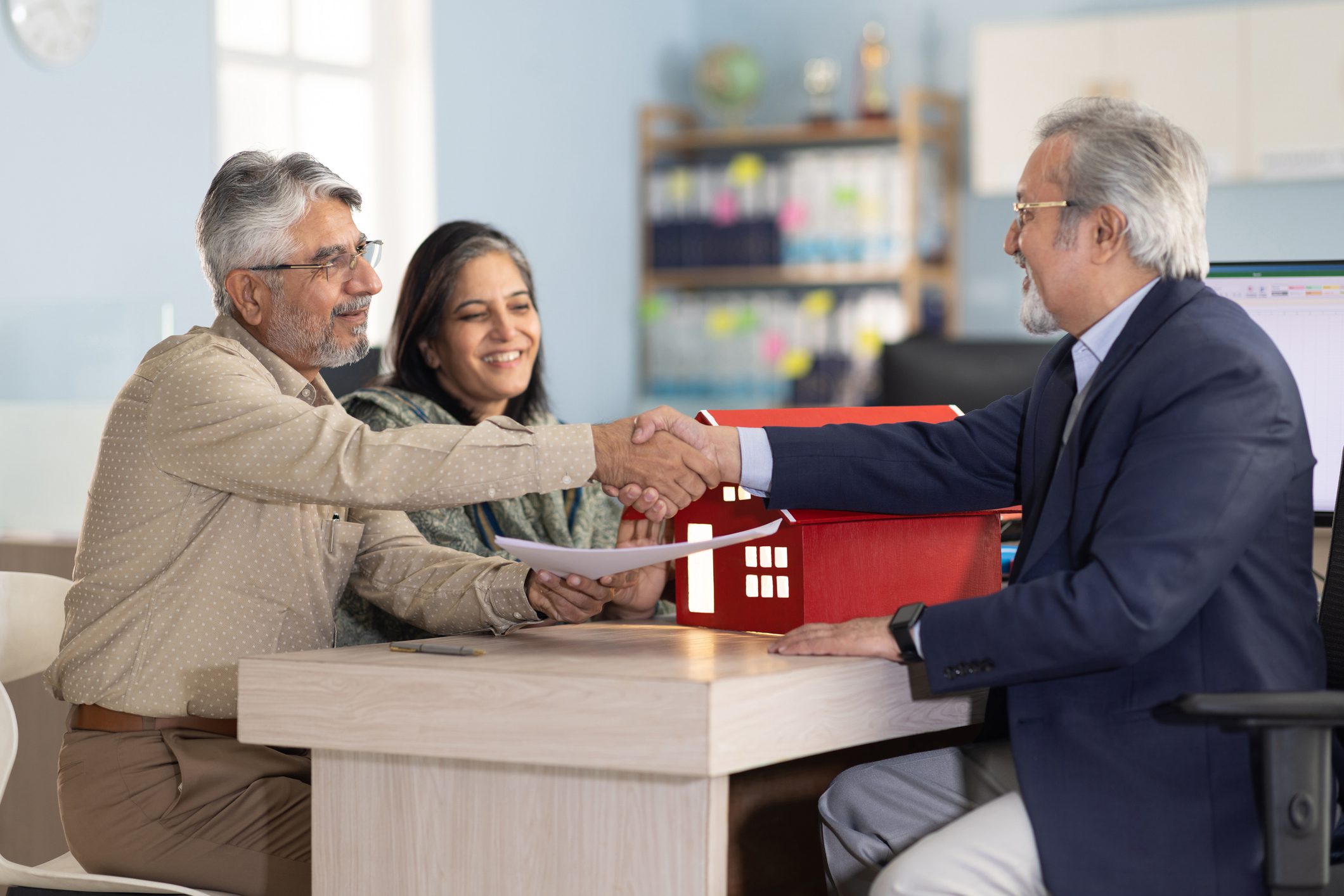 People shaking hands in an office meeting.